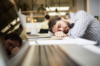 Photo d'un homme assoupi sur son bureau